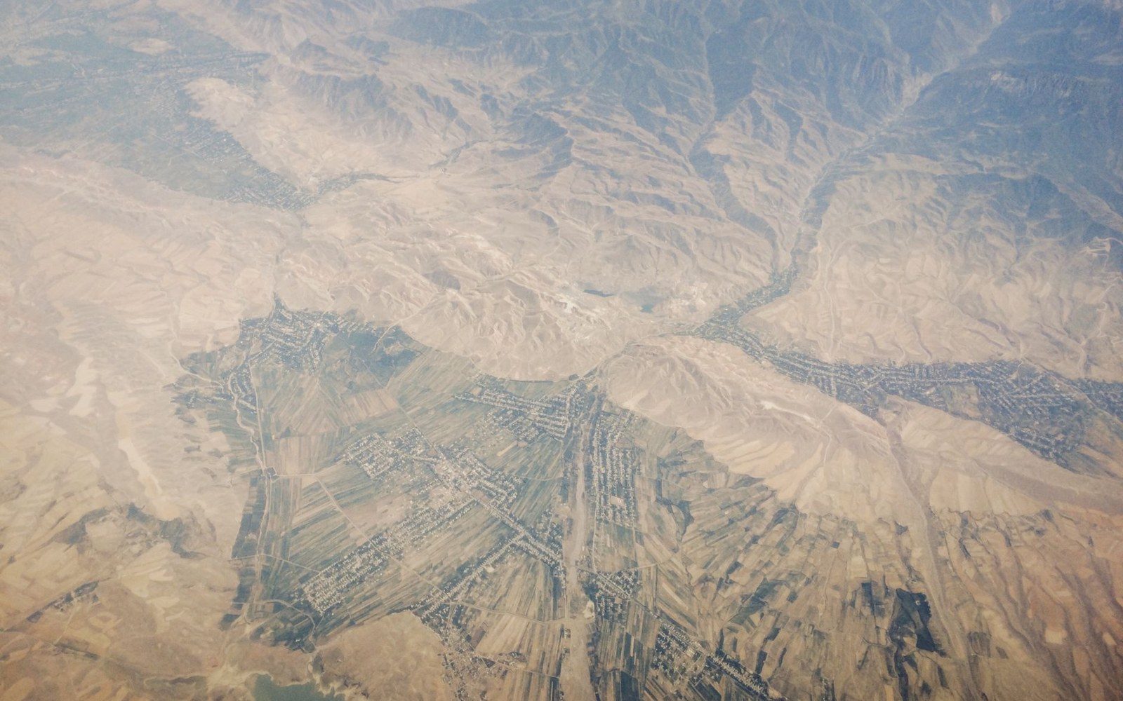 Aerial view of a mountainous valley with terraced farmland and scattered villages